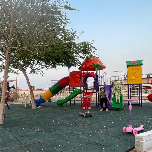 Children playing on colorful slides and swings at the new shaded playground in Al Jazeerah Equestrian Club, Ras Al Khaimah – a top family-friendly destination near Marjan Island.