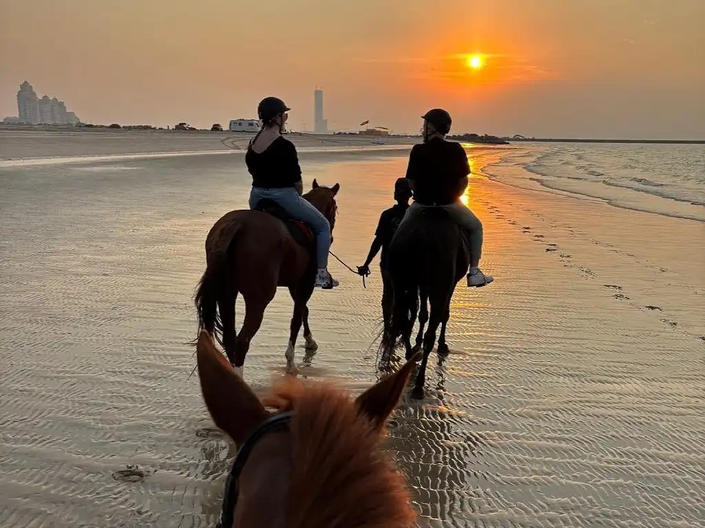 Riders enjoying a sunset beach horse riding experience along the coastline of Ras Al Khaimah, one of the most magical outdoor activities near Marjan Island and a popular day trip from Dubai.
